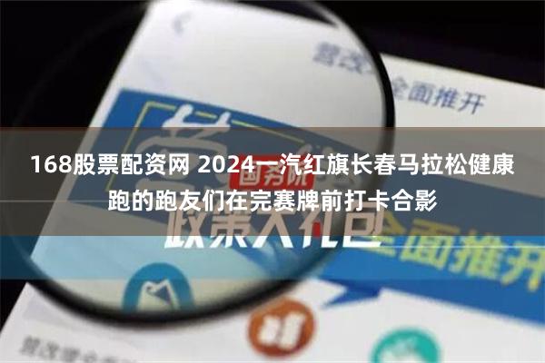 168股票配资网 2024一汽红旗长春马拉松健康跑的跑友们在完赛牌前打卡合影